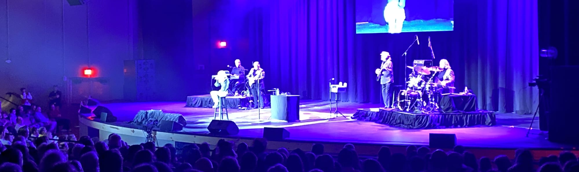 signer on stage in chair washed out by the lights Green Bay